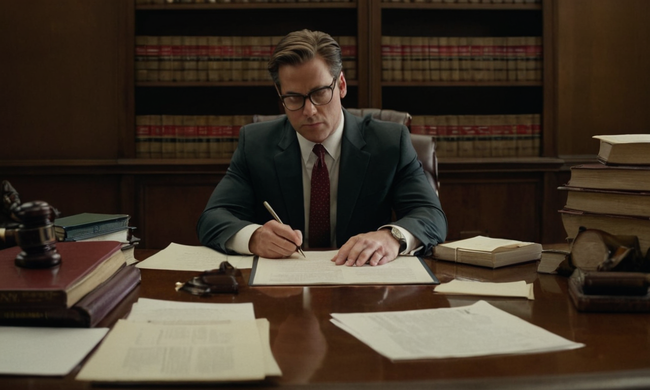A lawyer examining a contract on a desk, surrounded by legal texts and papers.