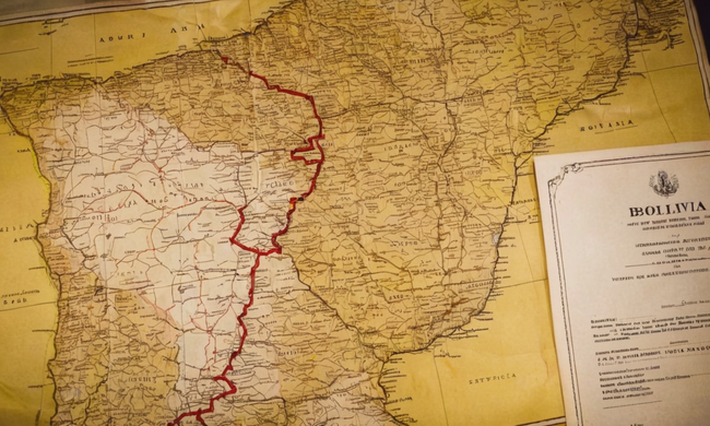 Mapa de Bolivia mostrando varias rutas de transferencia de tierras junto a un documento de abogados.